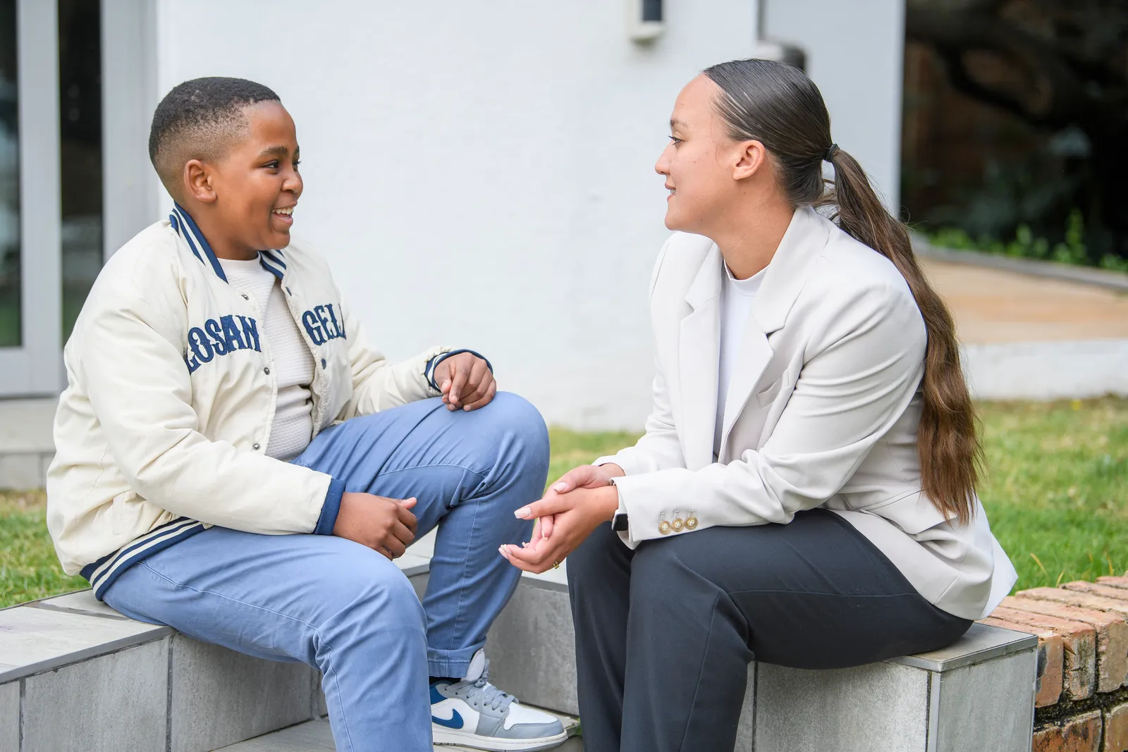 An Education Leader and young learner talking together outdoors
