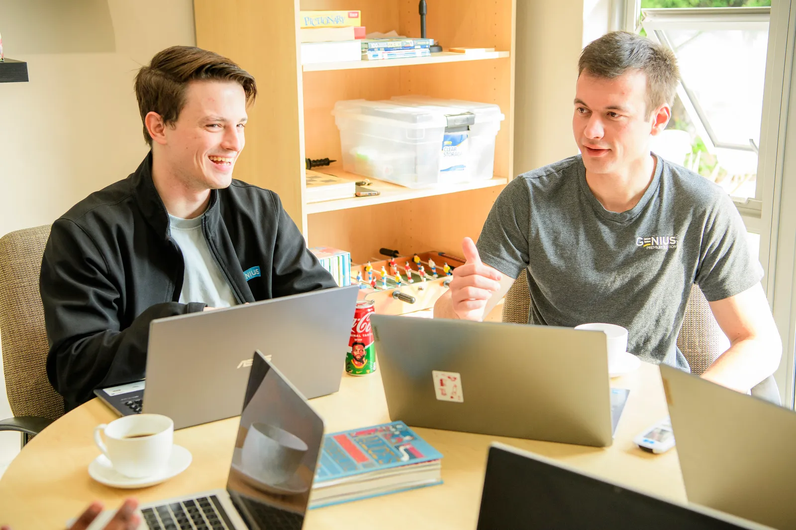 Two Genius colleagues collaborating over their laptops