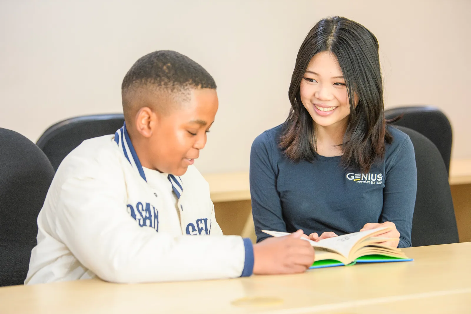 A Genius tutor supporting a young learner as he reads aloud